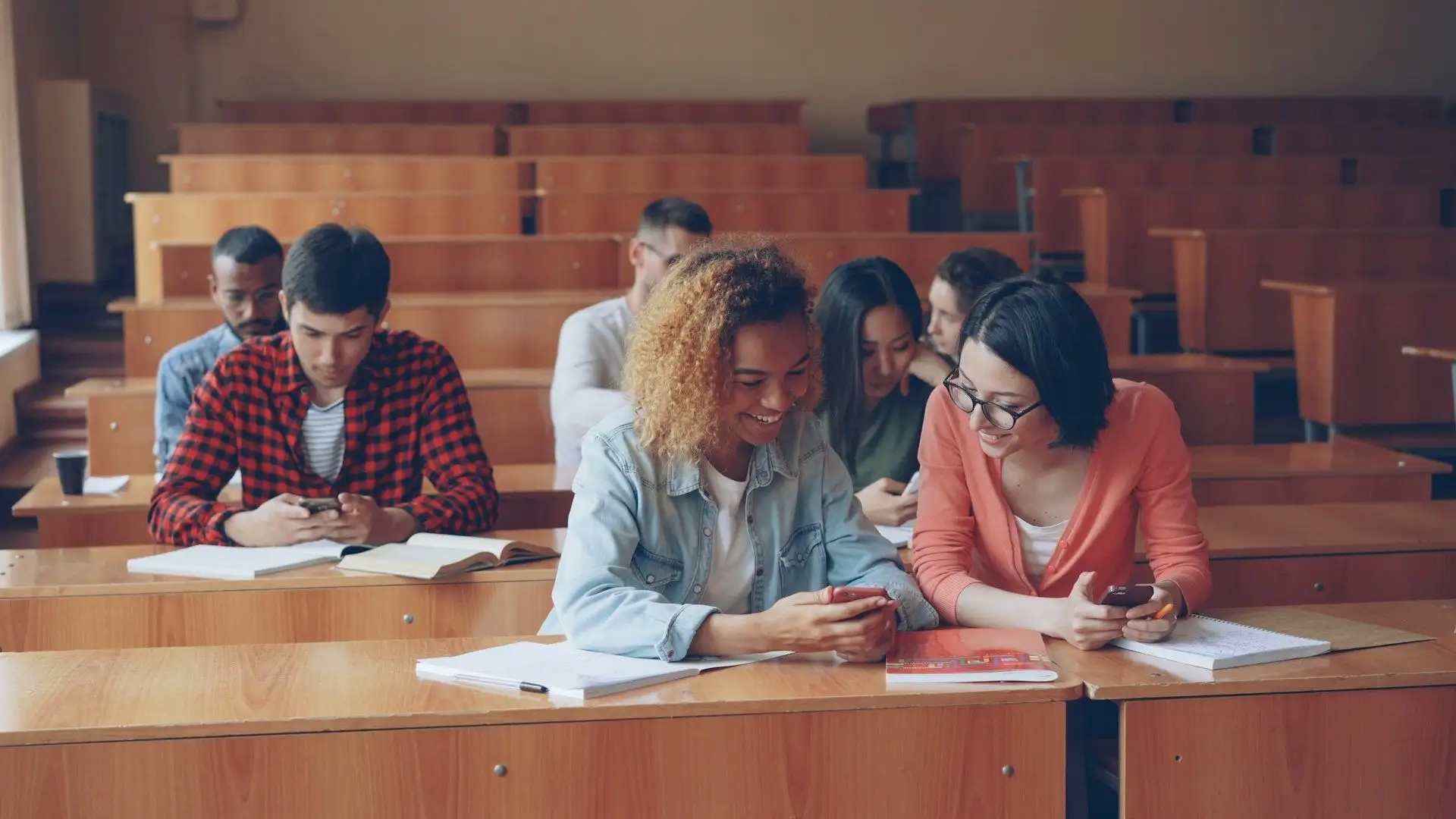 Students studying together in a tiered lecture theatre