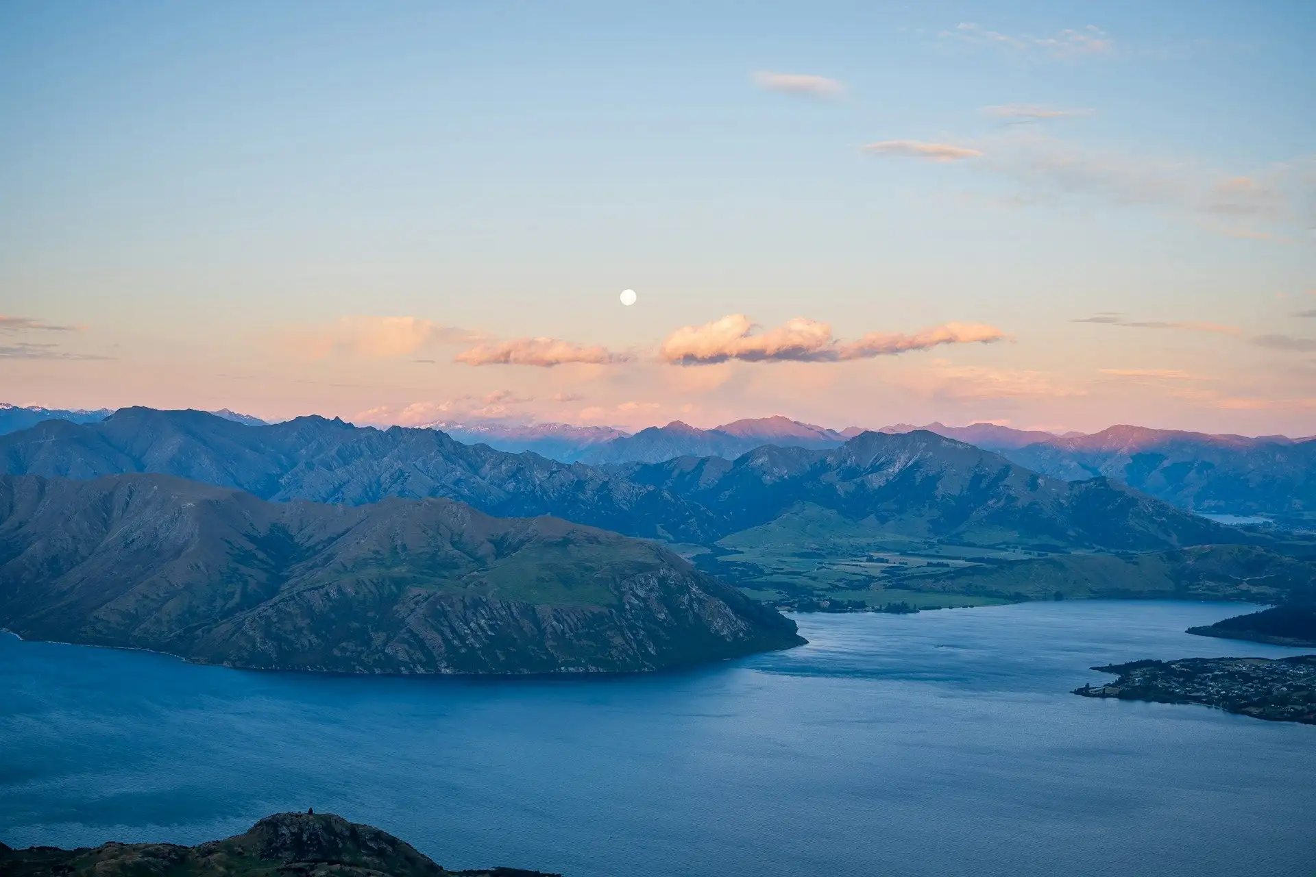 Pink dusk over Lake Wanaka and the mountains with the moon rising