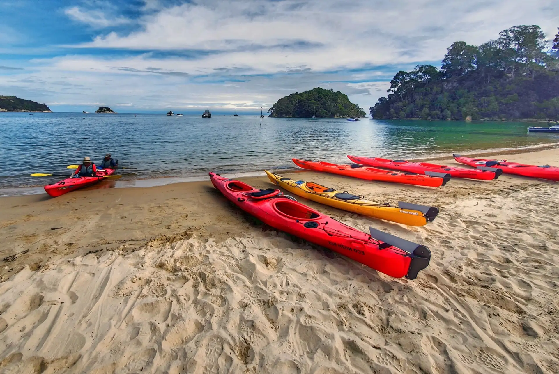 Red and yellow kayaks on the beach at Kaiteriteri