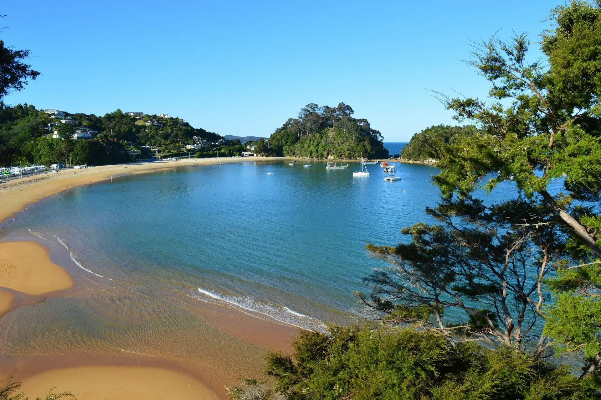 The blue bay and golden beach at Kaiteriteri under a bright sky