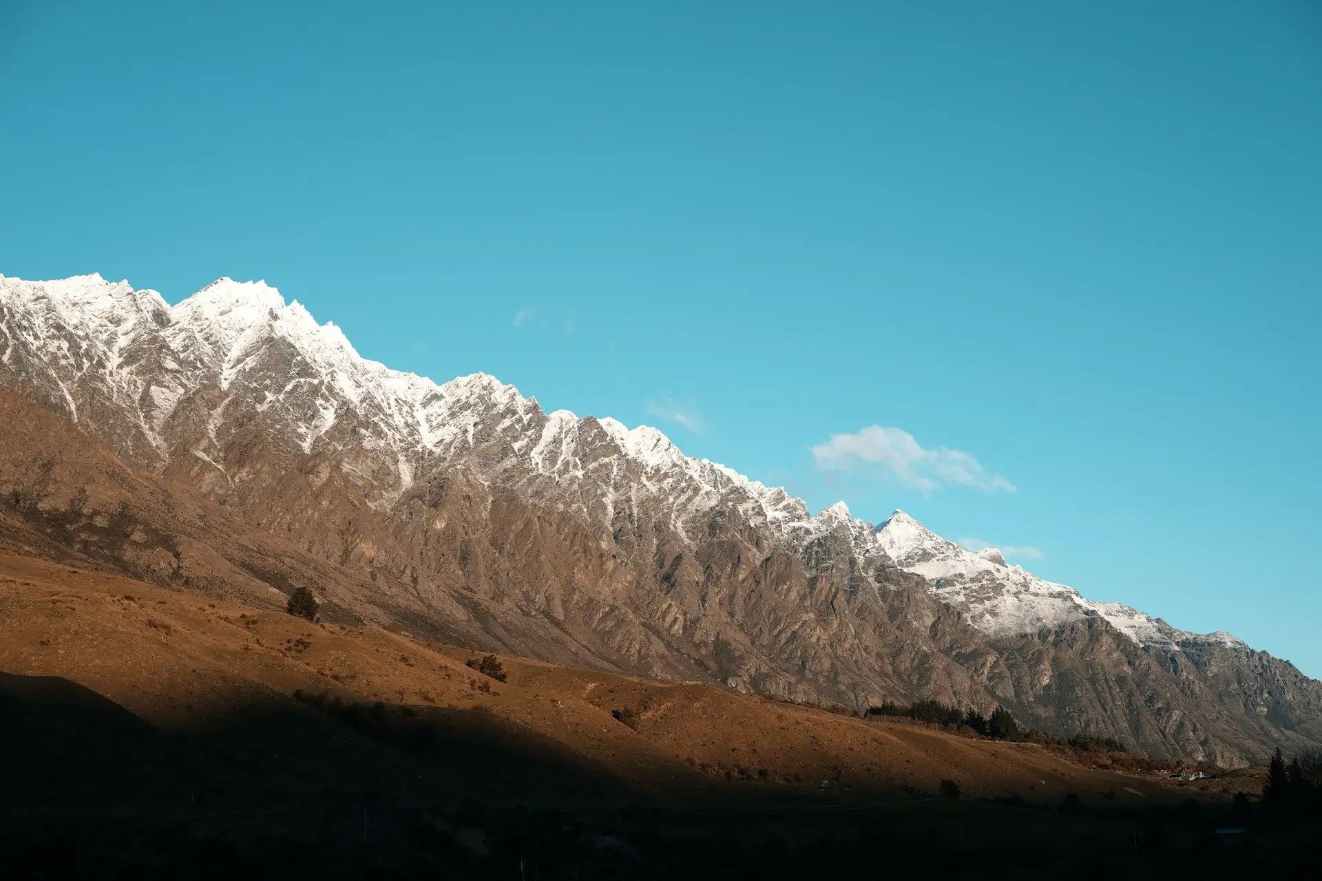 The snowy Remarkables ridgeline against a deep blue sky