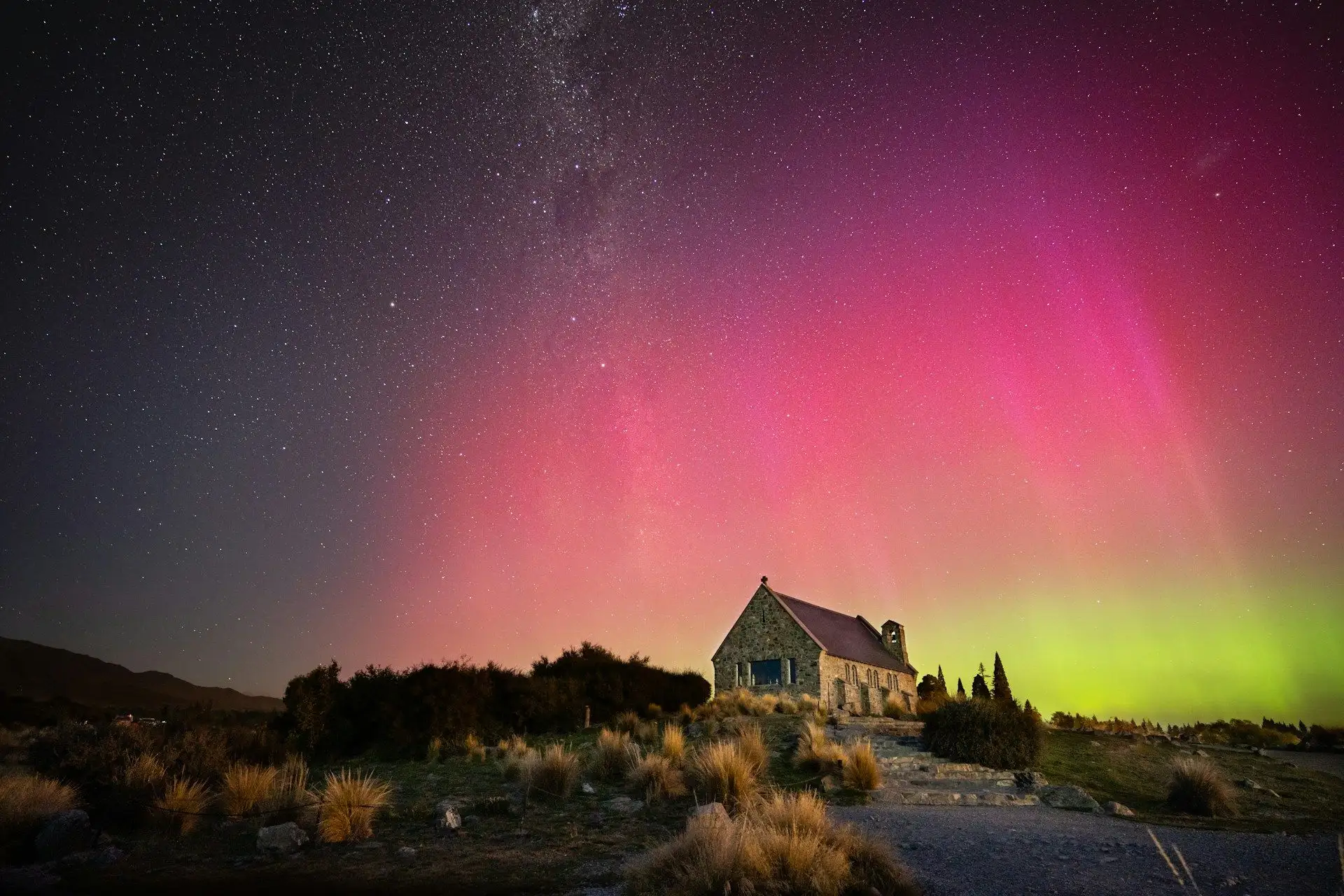 Aurora Australis glowing red and green above the Church of the Good Shepherd, Lake Tekapo