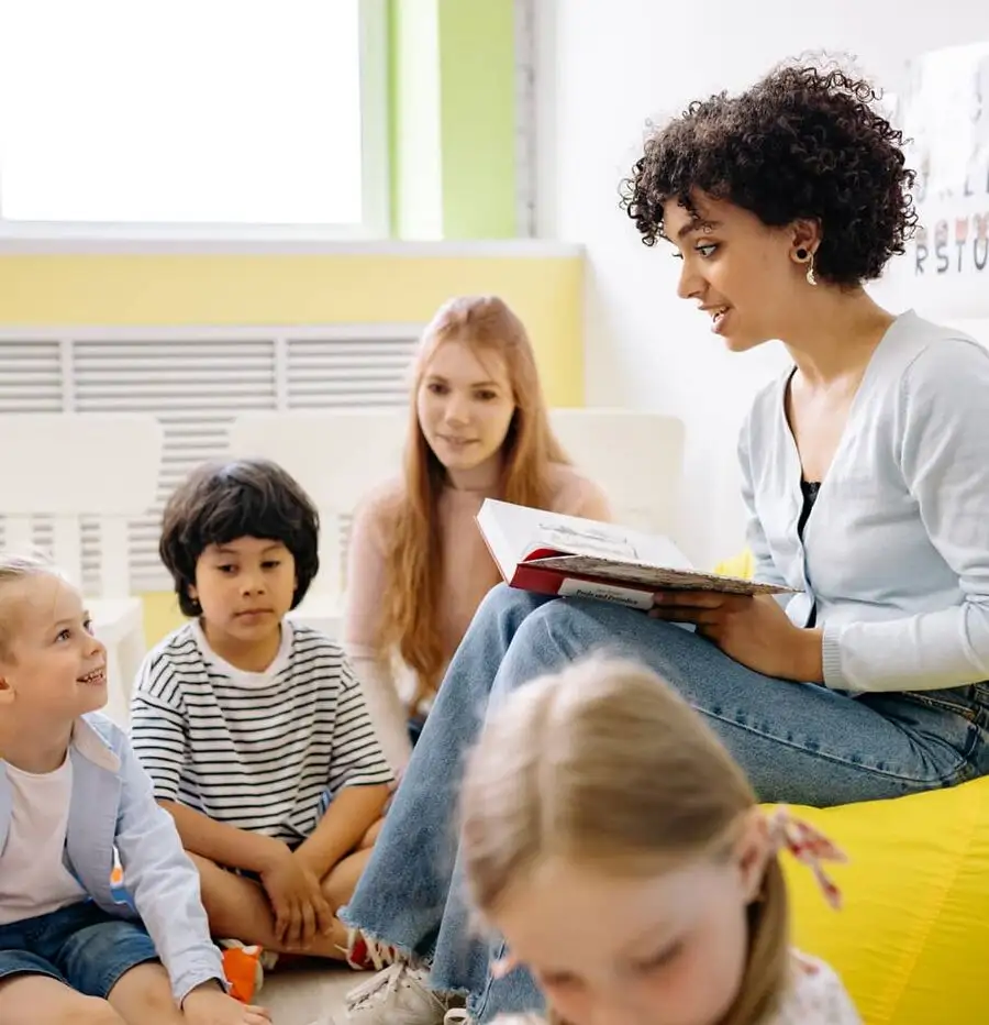 A teacher reading to a group of young students