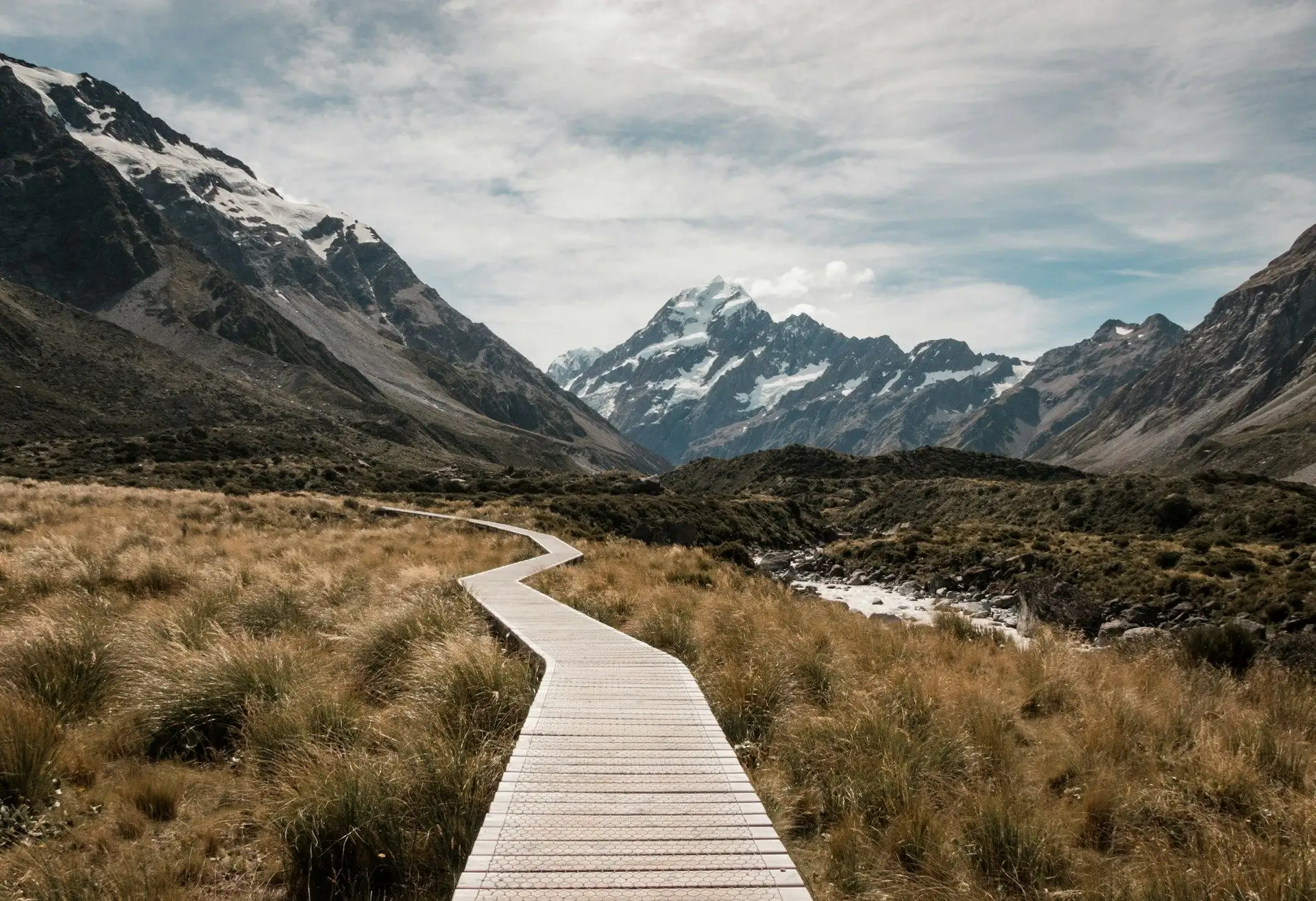 The Hooker Valley boardwalk winding through tussock towards Aoraki / Mount Cook