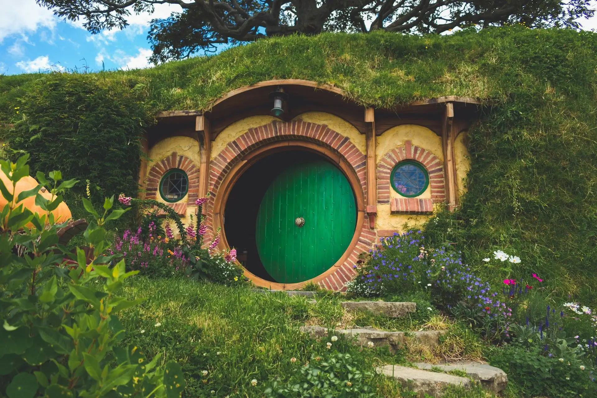 A round green door in a grassy hillside at Hobbiton