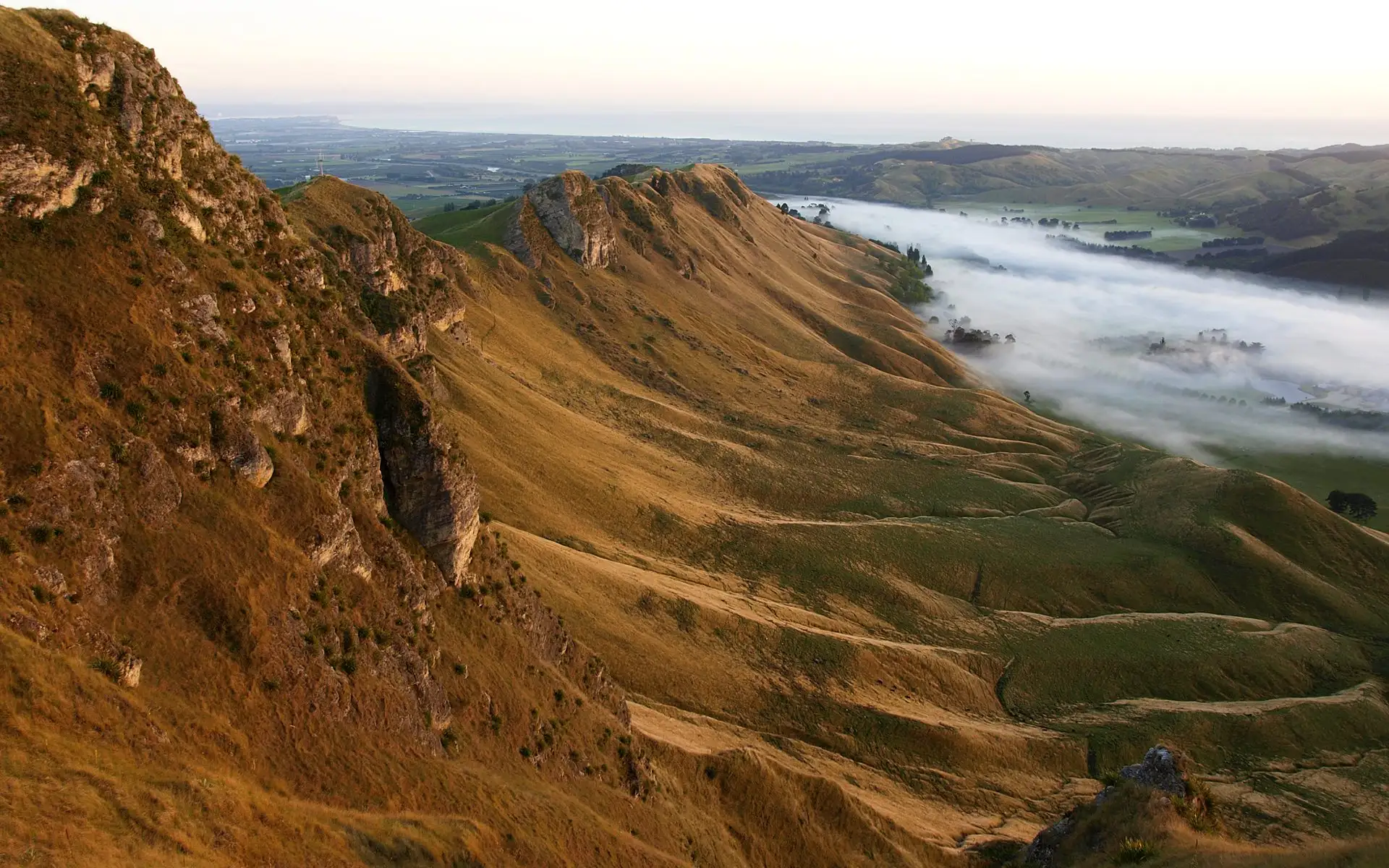 The golden ridge of Te Mata Peak above misty valleys in Hawke's Bay