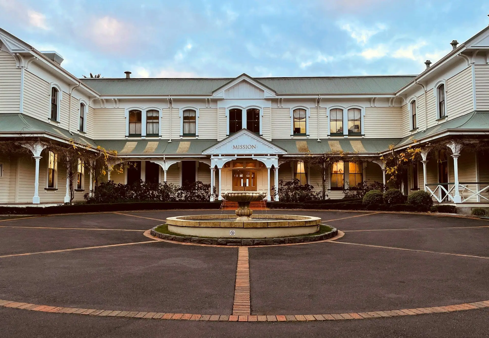 A historic homestead at a vineyard estate lit at dusk
